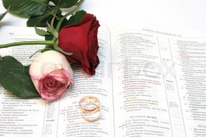 1999259-197602-two-red-roses-and-wedding-rings-on-bible